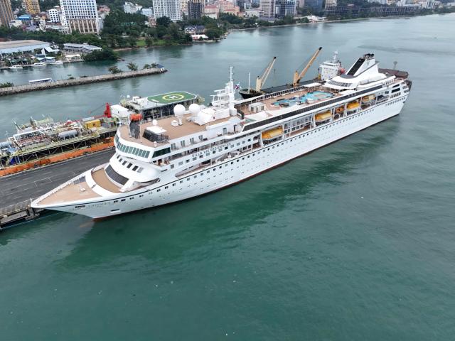 An aerial view shows the Villa Vie Residences' cruise ship Odyssey docked at Sihanoukville port in Preah Sihanouk province on October 28, 2026. Around 200 passengers who paid to live on a cruise ship while travelling the world were abruptly left in a Cambodian port after the company ran out of money, an official said on October 28. (Photo by Suy Se / AFP)