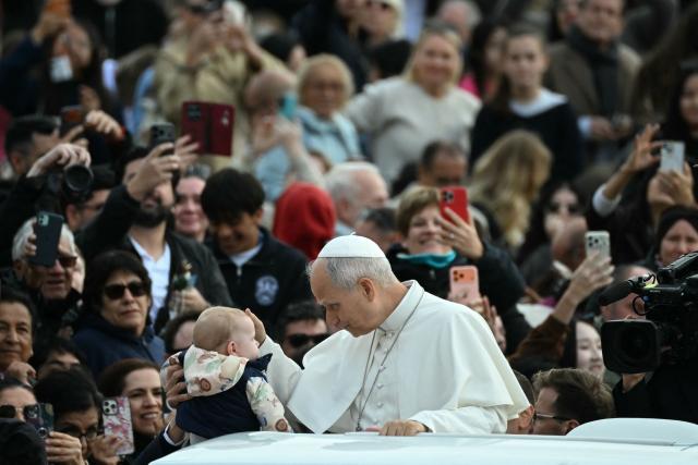 Pope Leo XIV blesses a young faithful along with pilgrims gathered in St. Peter's Square as he arrives to lead the weekly general audience at The Vatican on October 28, 2026. (Photo by Filippo MONTEFORTE / AFP)