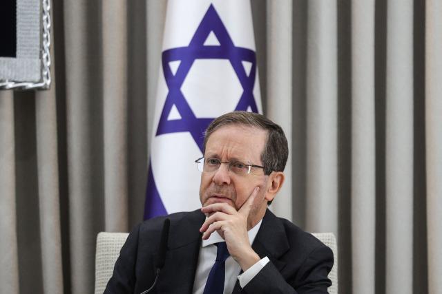 (FILES) Israel's President Isaac Herzog looks on during a meeting with the German Chancellor at his residence in Jerusalem on December 6, 2025. Israel's President Isaac Herzog is known for his unassuming and mild manner, but all eyes will soon be on him as he decides who to task with forming the next coalition government. The decision is a weighty one given that partial results show neither the camp of the Prime Minister Benjamin Netanyahu nor that of his rival Gadi Eisenkot securing a majority in parliament. (Photo by ABIR SULTAN / POOL / AFP)
