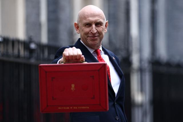 Britain's Chancellor of the Exchequer John Healey poses with the Budget Box as he leaves 11 Downing Street in central London on October 28, 2026, before presenting the government's annual budget to Parliament. On Wednesday, John Healey will present his first budget, which will test its ability to support purchasing power and increase defence spending, all while working with limited financial leeway. (Photo by Henry NICHOLLS / AFP)