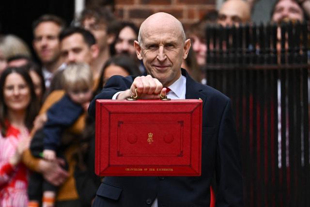 Britain's Chancellor of the Exchequer John Healey poses with the Budget Box as he leaves 11 Downing Street in central London on October 28, 2026, before presenting the government's annual budget to Parliament. On Wednesday, John Healey will present his first budget, which will test its ability to support purchasing power and increase defence spending, all while working with limited financial leeway. (Photo by Dylan Martinez / AFP)