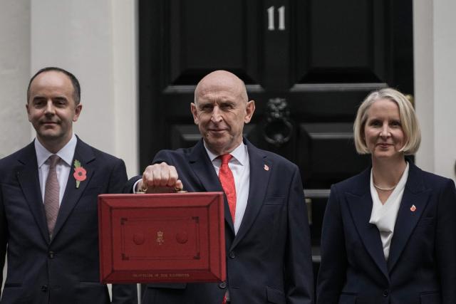 Britain's Chancellor of the Exchequer John Healey (C) holds the Budget Box as he leaves 11 Downing Street with Britain's Financial Secretary to the Treasury James Murray (L) and Britain's Chief Secretary to the Treasury Emma Reynolds (R) in central London on October 28, 2026, before presenting the government's annual budget to parliament. Healey will unveil his first budget on October 28 as he juggles commitments to defence spending and easing household bills with little financial room to manoeuvre. (Photo by CARLOS JASSO / AFP)