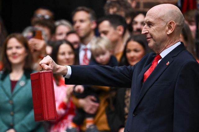 Britain's Chancellor of the Exchequer John Healey poses with the Budget Box as he leaves 11 Downing Street in central London on October 28, 2026, before presenting the government's annual budget to Parliament. On Wednesday, John Healey will present his first budget, which will test its ability to support purchasing power and increase defence spending, all while working with limited financial leeway. (Photo by Dylan Martinez / POOL / AFP)