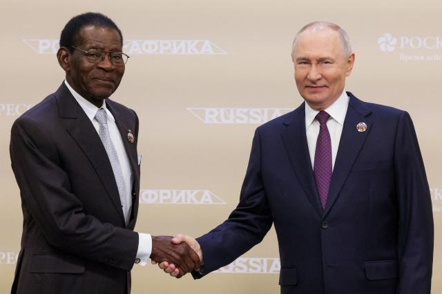 In this pool photograph distributed by the Russian state agency Sputnik, Russia's President Vladimir Putin welcomes Equatorial Guinea's President Teodoro Obiang Nguema Mbasogo prior to the Russia-Africa economic and humanitarian forum at the Gostiny Dvor conference centre in central Moscow on October 28, 2026. (Photo by Gavriil Grigorov / POOL / AFP)
