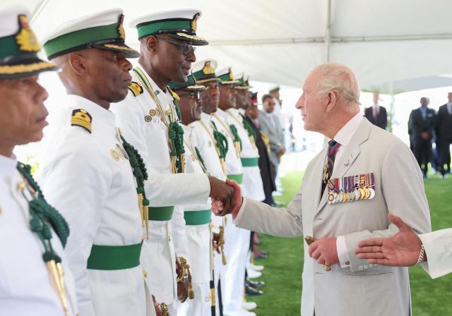 Britain's King Charles III greets retired members of the Royal Bahamas Defence Force during his visit to Coral Harbour Base in Nassau, Bahamas, on October 28, 2026. King Charles III's Autumn Tour includes visits to The Bahamas, Guyana and Antigua and Barbuda. (Photo by Chris Jackson / POOL / AFP)