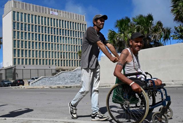 A man is pushed in his wheelchair in front of the US Embassy building in Havana on October 28, 2026. (Photo by YAMIL LAGE / AFP)