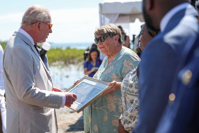 Britain's King Charles III receives artwork from resident Lynn Gape as he visits a mangrove ecosystem at Bonefish Pond National Park in New Providence, Nassau, The Bahamas, on October 28, 2026. King Charles III's Autumn Tour includes visits to The Bahamas, Guyana and Antigua and Barbuda. (Photo by Isabel Infantes / POOL / AFP)