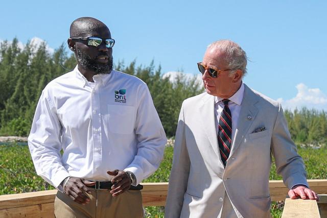 Britain's King Charles III speaks with Anwar Rolle, New Providence (NP) Parks Manager, as they walk along a wooden boardwalk through the mangrove ecosystem at Bonefish Pond National Park in New Providence, Nassau, The Bahamas on October 28, 2026. King Charles III's Autumn Tour includes visits to The Bahamas, Guyana and Antigua and Barbuda. (Photo by Isabel Infantes / POOL / AFP)