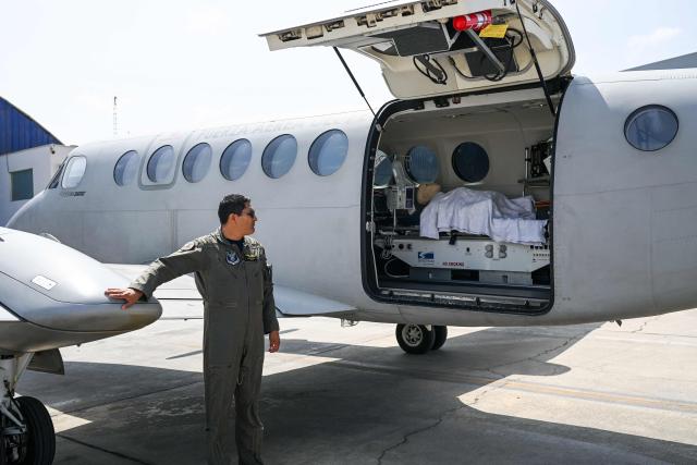 A member of the Peruvian Air Force (FAP) stands next to a Beechcraft King Air 360 air ambulance aircraft equipped with a medical cabin at Air Group No. 8 in Callao, Peru, on October 28, 2026, ahead of Pope Leo XIV's visit to Peru from November 11 to 16, 2026. (Photo by Connie FRANCE / AFP)