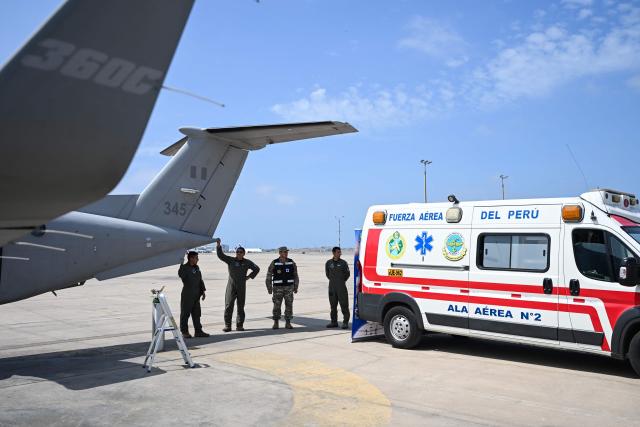 Members of the Peruvian Air Force (FAP) stand next to an ambulance and a Beechcraft King Air 360 air ambulance aircraft at Air Group No. 8 in Callao, Peru, on October 28, 2026, ahead of Pope Leo XIV's visit to Peru from November 11 to 16, 2026. (Photo by Connie FRANCE / AFP)