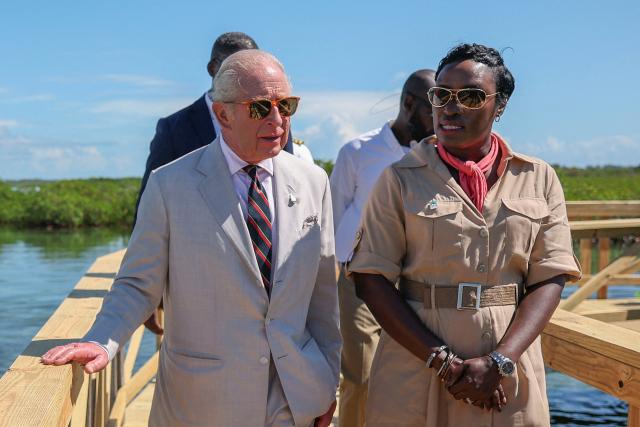 Britain's King Charles III speaks with Lakeshia Anderson-Rolle, Executive Director of the Bahamas National Trust (BNT), as they walk along a wooden boardwalk through the mangrove ecosystem at Bonefish Pond National Park in New Providence, Nassau, The Bahamas, on October 28, 2026. King Charles III's Autumn Tour includes visits to The Bahamas, Guyana and Antigua and Barbuda. (Photo by Isabel Infantes / POOL / AFP)