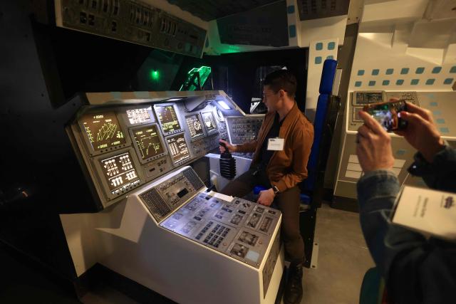 People interact with controls of NASA's Space Shuttle Endeavour displayed in its launch position at the Samuel Oschin Air and Space Center during a media preview at the California Science Center in Los Angeles, on October 28, 2026. The California Science Center’s Samuel Oschin Air and Space Center, the permanent home of Space Shuttle Endeavour, will open to the public on November 13, 2026. (Photo by David Swanson / AFP)