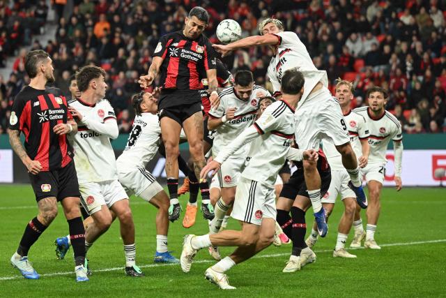 Players vie in the box as Bayer Leverkusen's Burkinabe defender #12 Edmond Tapsoba (hidden) scores the 1-2 goal during the German Cup (DFB-Pokal) football match between Bayer 04 Leverkusen and FC Nuernberg in Leverkusen, western Germany on October 28, 2026. (Photo by INA FASSBENDER / AFP) / DFB REGULATIONS PROHIBIT ANY USE OF PHOTOGRAPHS AS IMAGE SEQUENCES AND QUASI-VIDEO.