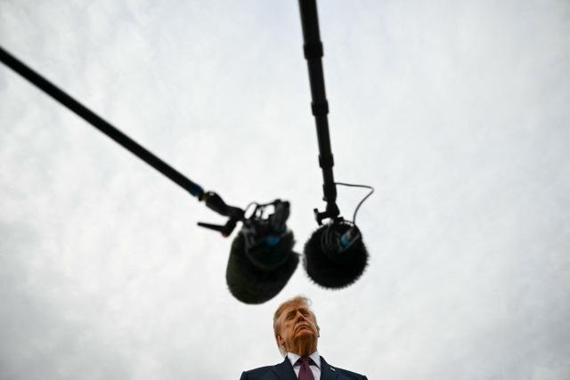 US President Donald Trump speaks with reporters before boarding Air Force One at Joint Base Andrews, Maryland, on October 28, 2026. President Trump is travelling to Ohio to speak at a midterm campaign rally. (Photo by Kent NISHIMURA / AFP)