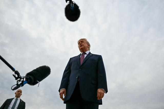 US President Donald Trump speaks with reporters before boarding Air Force One at Joint Base Andrews, Maryland, on October 28, 2026. President Trump is travelling to Ohio to speak at a midterm campaign rally. (Photo by Kent NISHIMURA / AFP)