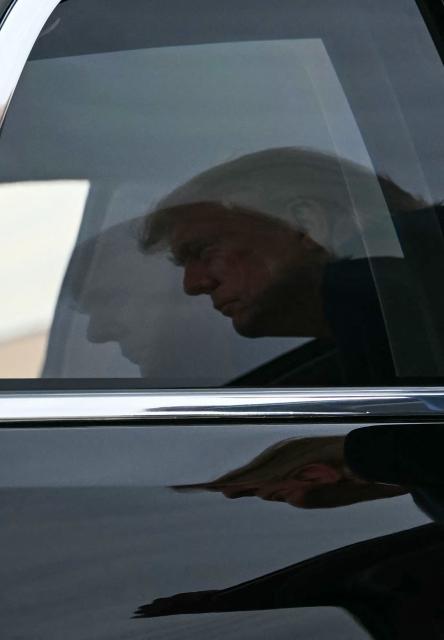US President Donald Trump is reflected in the presidential limousine's window as he arrives to board Air Force One at Joint Base Andrews, Maryland, on October 28, 2026. President Trump is travelling to Ohio to speak at a midterm campaign rally. (Photo by Kent NISHIMURA / AFP)