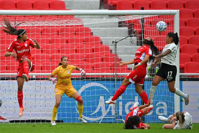Corinthians' midfielder #17 Victoria Albuquerque (R) jumps to head the ball past Indepediente Santa Fe's goalkeeper #26 Jimena Osipna (2nd L) during the 2026 Women's Copa Libertadores semi-final football match between Brazil's Corinthians and Colombia's Independiente Santa Fe at the Rodrigo Paz Delgado stadium in Quito on October 28, 2026. (Photo by Rodrigo BUENDIA / AFP)