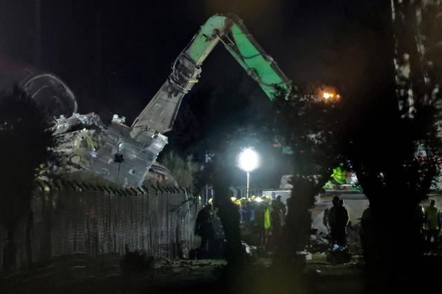 Damaged carriages are removed with heavy machinery at the site of a train crash between two high-speed units, a Renfe AVE train and an Iryo train around 150 km south of Madrid between Urda and Los Yebenes in the province of Toledo, on October 28, 2026. A high-speed train collision south of Madrid killed 68 people and injured scores more today, authorities said, in one of Europe's deadliest such disasters this century. The second such accident to strike Spain this year will raise fresh questions about the country's rail safety, with the transport minister speaking of an "error" and "inexplicable circumstances" that led to the crash. (Photo by Oscar DEL POZO / AFP)