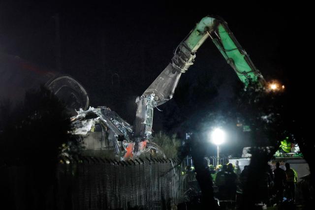 Damaged carriages are removed with heavy machinery at the site of a train crash between two high-speed units, a Renfe AVE train and an Iryo train around 150 km south of Madrid between Urda and Los Yebenes in the province of Toledo, on October 28, 2026. A high-speed train collision south of Madrid killed 68 people and injured scores more today, authorities said, in one of Europe's deadliest such disasters this century. The second such accident to strike Spain this year will raise fresh questions about the country's rail safety, with the transport minister speaking of an "error" and "inexplicable circumstances" that led to the crash. (Photo by Oscar DEL POZO / AFP)