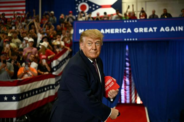 US President Donald Trump throws MAGA hats to the crowd upon arrival to speak at a midterm campaign rally at Shoemaker Center in Chillicothe, Ohio, on October 28, 2026. (Photo by Kent NISHIMURA / AFP)