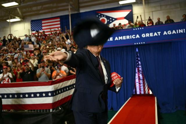 US President Donald Trump throws MAGA hats to the crowd upon arrival to speak at a midterm campaign rally at Shoemaker Center in Chillicothe, Ohio, on October 28, 2026. (Photo by Kent NISHIMURA / AFP)