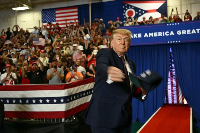 US President Donald Trump throws MAGA hats to the crowd upon arrival to speak at a midterm campaign rally at Shoemaker Center in Chillicothe, Ohio, on October 28, 2026. (Photo by Kent NISHIMURA / AFP)