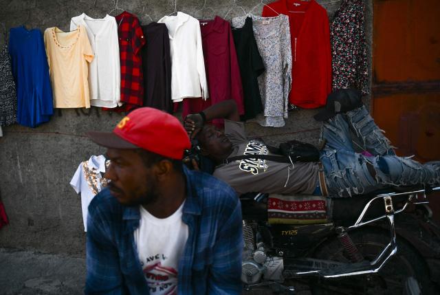 A motocyclist sleeps on his bike in the street, in Port-au-Prince, Haiti, on October 28, 2026. (Photo by Clarens SIFFROY / AFP)