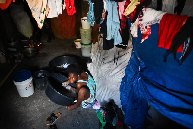 A person washes clothes in a displaced persons camp in Port-au-Prince, Haiti, on October 28, 2026. (Photo by Clarens SIFFROY / AFP)