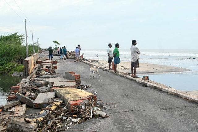 People look out to sea after cyclone Arnab's landfall in Andhra Pradesh's Kakinada on October 29, 2026. Ferocious winds and torrential rain lashed India's southeastern coast after a cyclone made landfall on October 28, killing at least three people before the storm weakened, officials said. (Photo by NOAH SEELAM / AFP)
