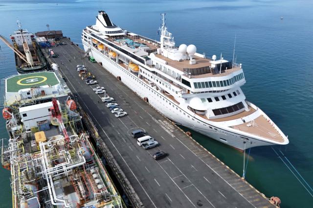 An aerial view shows the Villa Vie Residences' cruise ship Odyssey docked at Sihanoukville port in Preah Sihanouk province on October 29, 2026. Around 200 passengers who paid to live on a cruise ship while travelling the world were abruptly left in a Cambodian port after the company ran out of money, an official said on October 28. (Photo by Suy SE / AFP)