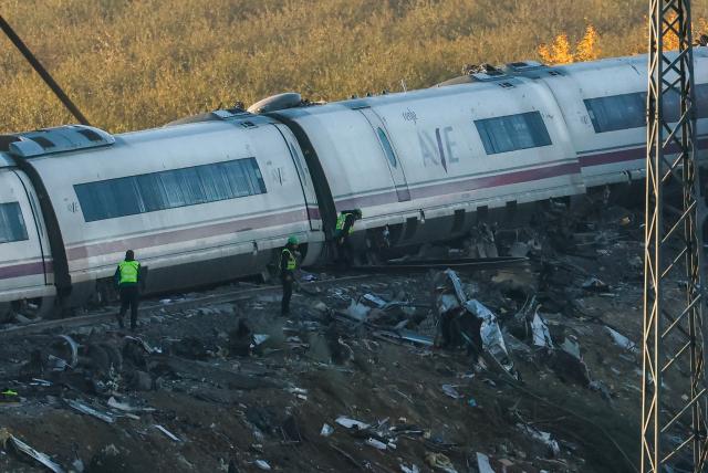 Investigators survey debris amongst the damaged carriages of a train crash between two high-speed units, a Renfe AVE train and an Iryo train around 150 km south of Madrid between Urda and Los Yebenes in the province of Toledo, a day after the accident on October 29, 2026. A high-speed train collision south of Madrid killed 68 people and injured scores more, authorities said, in one of Europe's deadliest such disasters this century. The second such accident to strike Spain this year will raise fresh questions about the country's rail safety, with the transport minister speaking of an "error" and "inexplicable circumstances" that led to the crash. (Photo by Oscar DEL POZO / AFP)