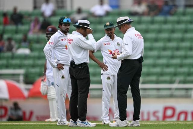 Field umpires check the shape of a ball as Bangladesh's captain Najmul Hossain Shanto (L) watches during the second day of the first test cricket match between Bangladesh and West Indies at the Sher-e-Bangla National Stadium in Mirpur on October 29, 2026. (Photo by Salahuddin Ahmed / AFP)