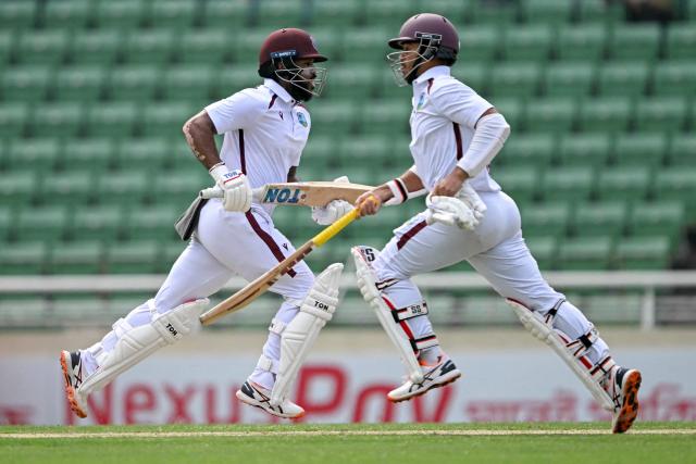 West Indies' John Campbell (L) and teammate Tagenarine Chanderpaul run between the wickets during the second day of the first test cricket match between Bangladesh and West Indies at the Sher-e-Bangla National Stadium in Mirpur on October 29, 2026. (Photo by Salahuddin Ahmed / AFP)