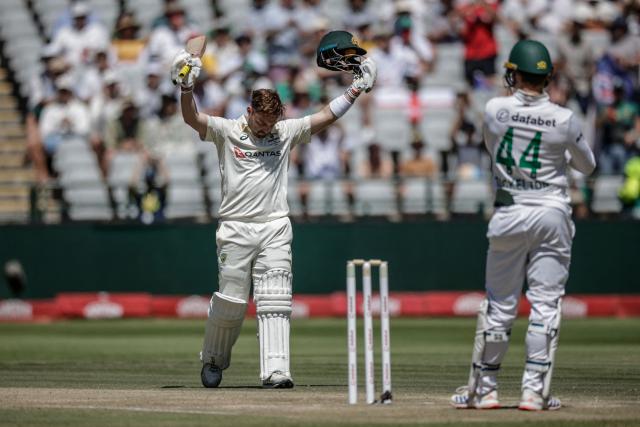 Australia's Josh Inglis raises his bat and helmet to celebrate after scoring a century (100 runs) on day three of the third Test match between South Africa and Australia at Newlands stadium in Cape Town on October 29, 2026. (Photo by Marco Longari / AFP)