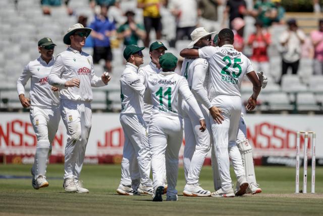 South Africa's Kagiso Rabada (R) celebrates with his teammates after dismissing Australia's Pat Cummins on day three of the third Test match between South Africa and Australia at Newlands stadium in Cape Town on October 29, 2026. (Photo by Marco Longari / AFP)