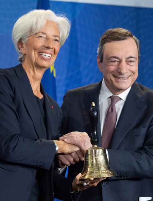(FILES) Mario Draghi (R), then outgoing President of the European Central Bank (ECB) presents a bell to his successor Christine Lagarde at a handing over ceremony Frankfurt am Main, western Germany on October 28, 2019. Christine Lagarde is to step down as President of the ECB on February 7, 2027, it was announced on October 29, 2026. (Photo by Boris Roessler / POOL / AFP)