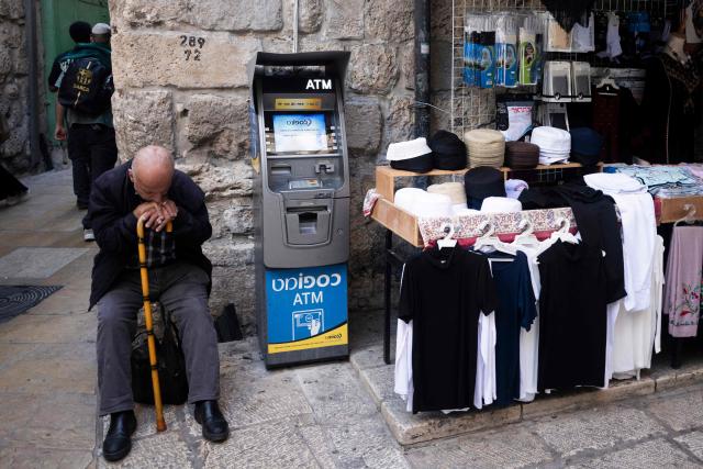 A man rests sitting next to a store in the Old City of Jerusalem on October 29, 2026. (Photo by Jewel SAMAD / AFP)
