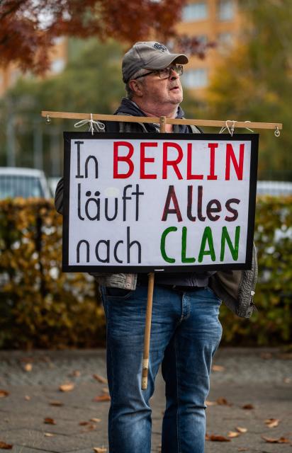 A demonstrator displays a placard reading: "In Berlin, everything runs according to the clan" during a protest outside the headquarters of the Social Democratic Party (SPD) in Berlin on October 29, 2026, criticising the SPD, the Left Party, as well as the Green party who are seeking to form a coalition government in Berlin. (Photo by John MACDOUGALL / AFP)