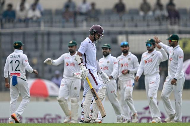 West Indies' Tagenarine Chanderpaul (C) walks back to the pavilion after his dismissal during the third day of the first test cricket match between Bangladesh and West Indies at the Sher-e-Bangla National Stadium in Mirpur on October 30, 2026. (Photo by Salahuddin Ahmed / AFP)