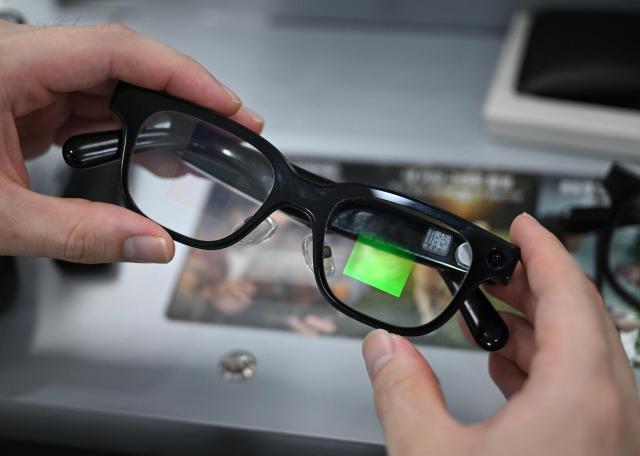 An optometrist holds a pair of smart glasses at the Eyedaq eyewear store in Seoul on October 30, 2026. South Korea will file criminal complaints against students caught cheating with smart glasses and toughen penalties for their use, a government official told AFP on October 30. (Photo by Jung Yeon-je / AFP)
