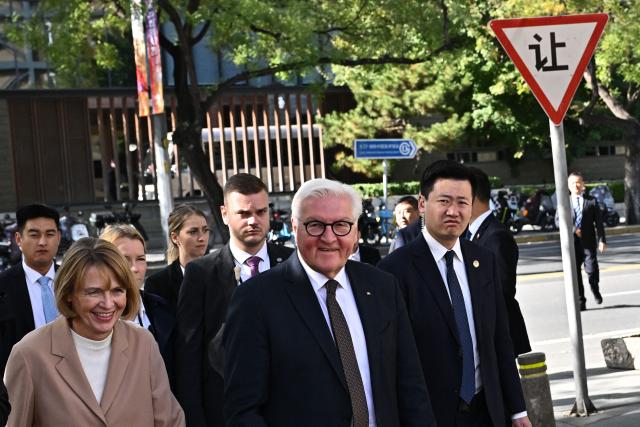 German President Frank-Walter Steinmeier (C) and his wife Elke Budenbender (L) visit the Renyi Theatre in Beijing on October 30, 2026. (Photo by Pedro PARDO / AFP)