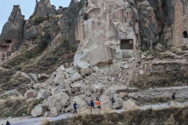 Officials inspect the site of a rock formation that collapsed due to a landslide triggered by heavy rains in Cappadocia district of Nevsehir, on October 30, 2026. A landslide triggered by heavy rainfall caused a rock spire to collapse in Turkey's UNESCO World Heritage-listed Cappadocia region on Thursday, killing at least two people, officials said. (Photo by Adem ALTAN / AFP)