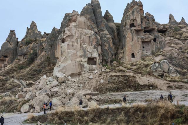 Officials inspect the site of a rock formation that collapsed due to a landslide triggered by heavy rains in Cappadocia district of Nevsehir, on October 30, 2026. A landslide triggered by heavy rainfall caused a rock spire to collapse in Turkey's UNESCO World Heritage-listed Cappadocia region on Thursday, killing at least two people, officials said. (Photo by Adem ALTAN / AFP)