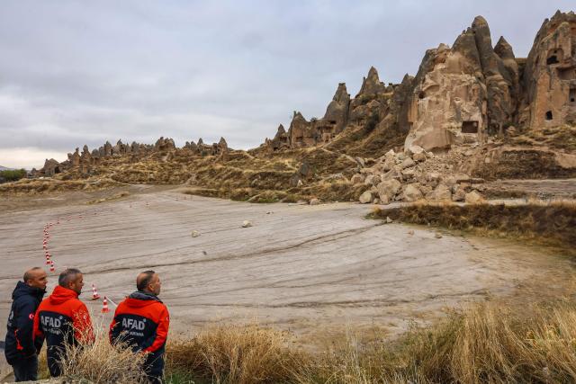 Officials inspect the site of a rock formation that collapsed due to a landslide triggered by heavy rains in Cappadocia district of Nevsehir, on October 30, 2026. A landslide triggered by heavy rainfall caused a rock spire to collapse in Turkey's UNESCO World Heritage-listed Cappadocia region on Thursday, killing at least two people, officials said. (Photo by Adem ALTAN / AFP)