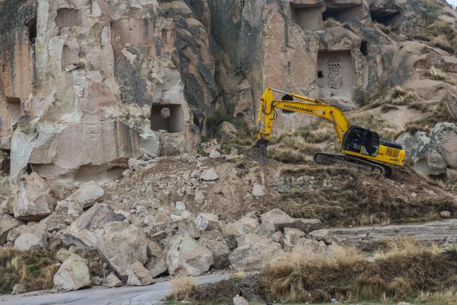 An excavator breaks up rocks for safety reasons at the site of a rock formation that collapsed due to a landslide triggered by heavy rains in Cappadocia district of Nevsehir, on October 30, 2026. A landslide triggered by heavy rainfall caused a rock spire to collapse in Turkey's UNESCO World Heritage-listed Cappadocia region on Thursday, killing at least two people, officials said. (Photo by Adem ALTAN / AFP)