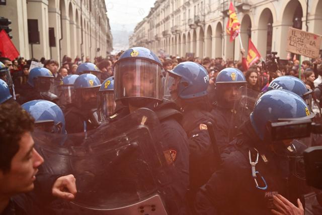 Students faces Italian police officers during a demonstration part of a nationwide day of strikes and protests as school and university students demand more funding for schools and support for housing, inTurin on October 30, 2026. Students have been protesting for weeks, setting up tent camps and occupying schools to make their demands heard, matching similar movements across the border in France. The Italian protests have taken place alongside those of truck drivers and farmers over the spike in fuel prices and the cost of living, as well as rising defence spending. (Photo by Marco BERTORELLO / AFP)