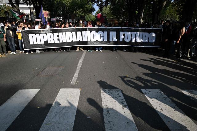Protesters hold a banner reading "Let's reclaim our future" during a demonstration part of a nationwide day of strikes and protests as school and university students demand more funding for schools and support for housing, in Milan, northern Italy on October 30, 2026. Students have been protesting for weeks, setting up tent camps and occupying schools to make their demands heard, matching similar movements across the border in France. The Italian protests have taken place alongside those of truck drivers and farmers over the spike in fuel prices and the cost of living, as well as rising defence spending. (Photo by PIERO CRUCIATTI / AFP)