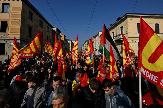 Protesters wave flags of the Unione Sindacale di base during a demonstration part of a nationwide day of strikes and protests as school and university students demand more funding for schools and support for housing, in Milan, northern Italy on October 30, 2026. Students have been protesting for weeks, setting up tent camps and occupying schools to make their demands heard, matching similar movements across the border in France. The Italian protests have taken place alongside those of truck drivers and farmers over the spike in fuel prices and the cost of living, as well as rising defence spending. (Photo by Stefano Rellandini / AFP)