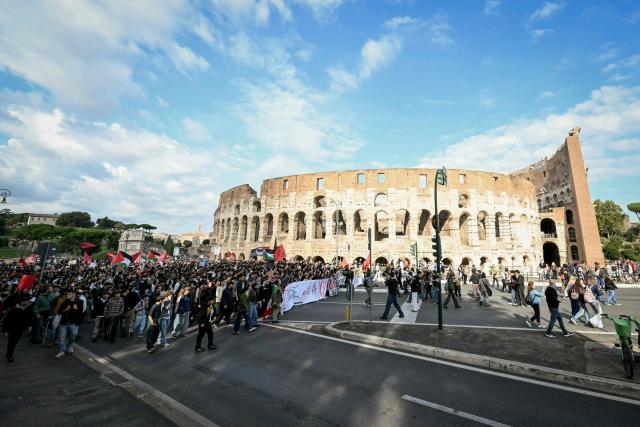 People pass by the Colosseum during a demonstration part of a nationwide day of strikes and protests as school and university students demand more funding for schools and support for housing in Rome on October 30, 2026. Students have been protesting for weeks, setting up tent camps and occupying schools to make their demands heard, matching similar movements across the border in France. The Italian protests have taken place alongside those of truck drivers and farmers over the spike in fuel prices and the cost of living, as well as rising defence spending. (Photo by Andreas SOLARO / AFP)