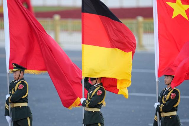 Chinese honor guards hold national flags of China and Germany during a welcoming ceremony held for the visit of Germany’s President Frank-Walter Steinmeier outside the Great Hall of the People in Beijing on October 30, 2026. (Photo by Kai Naito / POOL / AFP)
